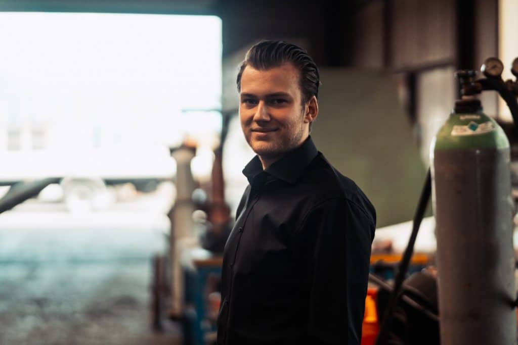 Portraitaufnahme eines jungen Mannes in einem Industriebetrieb