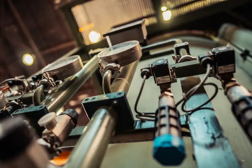 man sieht Verrohrung, sowie kleine Pumpen und Zähler für Wasser- (oder andere Flüssigkeits-) Stände.