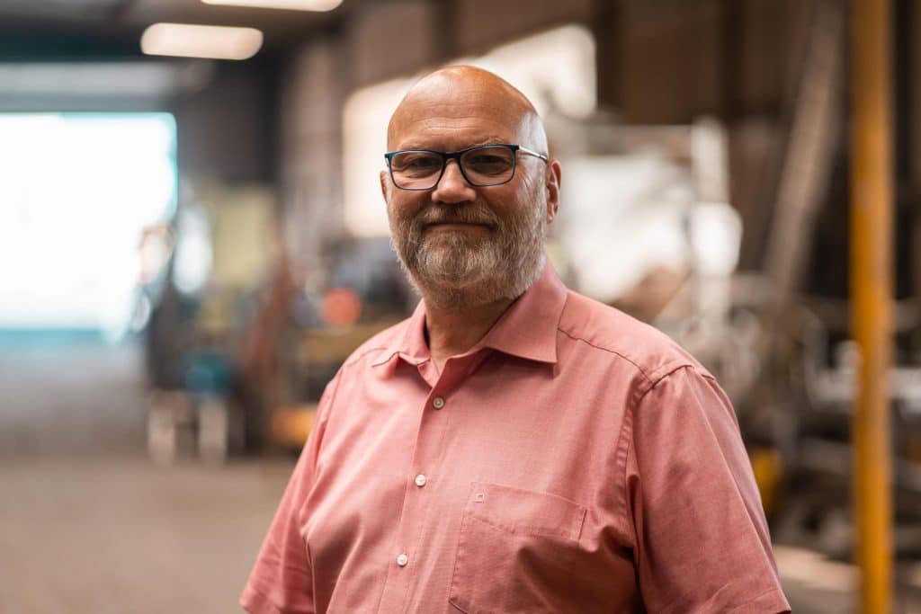 Porträtaufnahme eines Mannes in einem Industriebetrieb