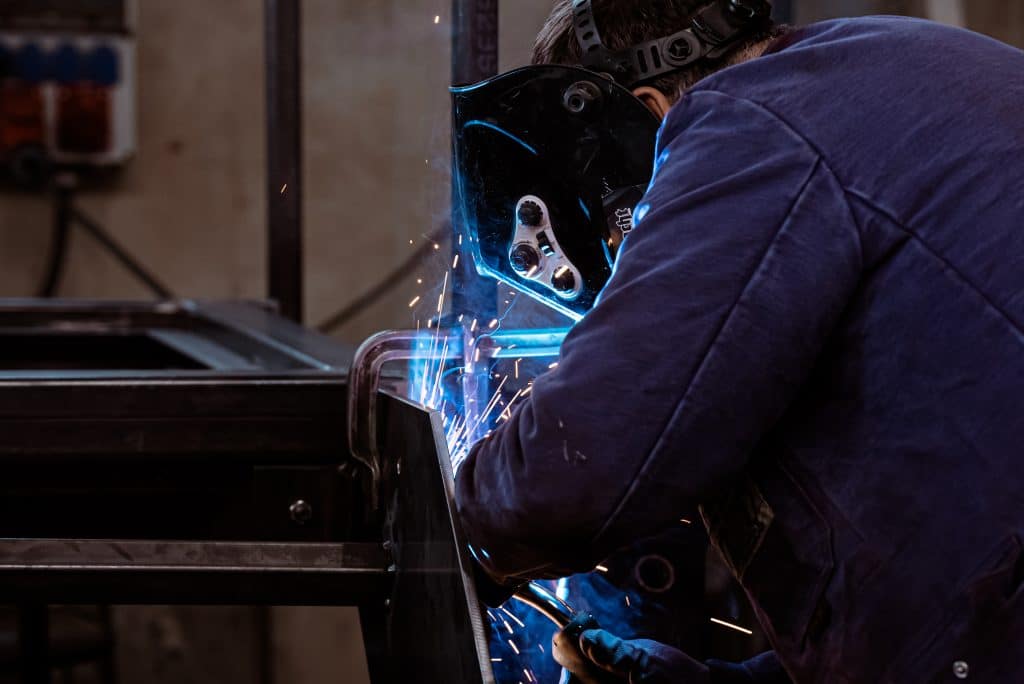 Schweißtechnik 3 Ein Mann schweißt eine Stahl/Edelstahlplatten aneinander. er trägt eine Schweißerschutzmaske