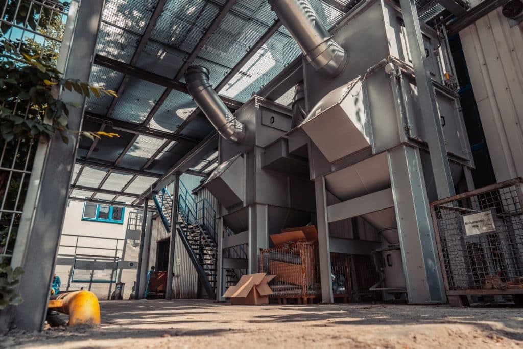 Laufsteg über einer Absaugeinheit aus Stahl. Im Hintergrund ist eine Stahltreppe für den Außenbereich zu sehen